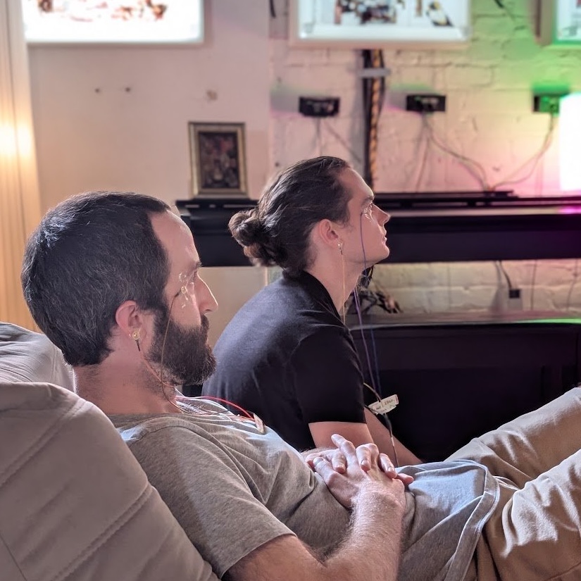 Two wired-up players sit side by side, eyes fixed on the game.